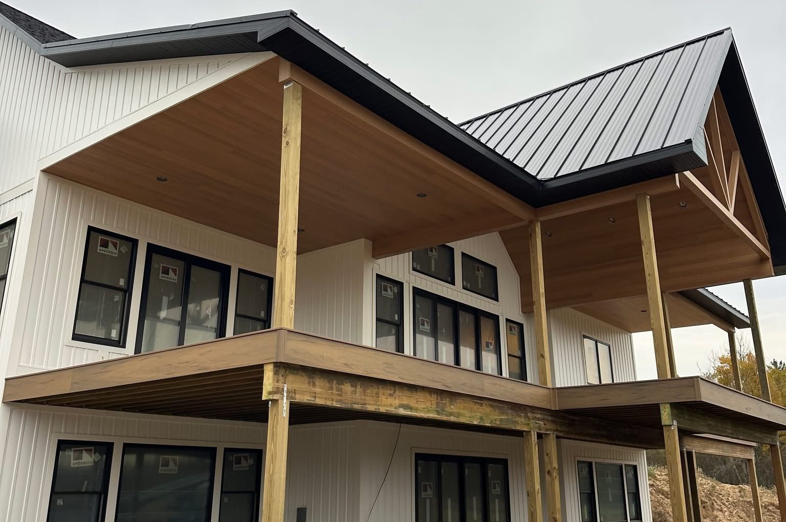 Modern farmhouse with covered decks and a metal roof, built by Wagner Home & Outdoor